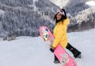 Frau fährt Snowboard in den Alpen